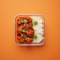 Crispy gochujang cauliflower with rice, sesame seeds, spring onions and coriander on a warm orange background